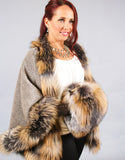 A red haired woman is wearing a medium length taupe cape with Cross Fox trim and dark brown leather gloves. 